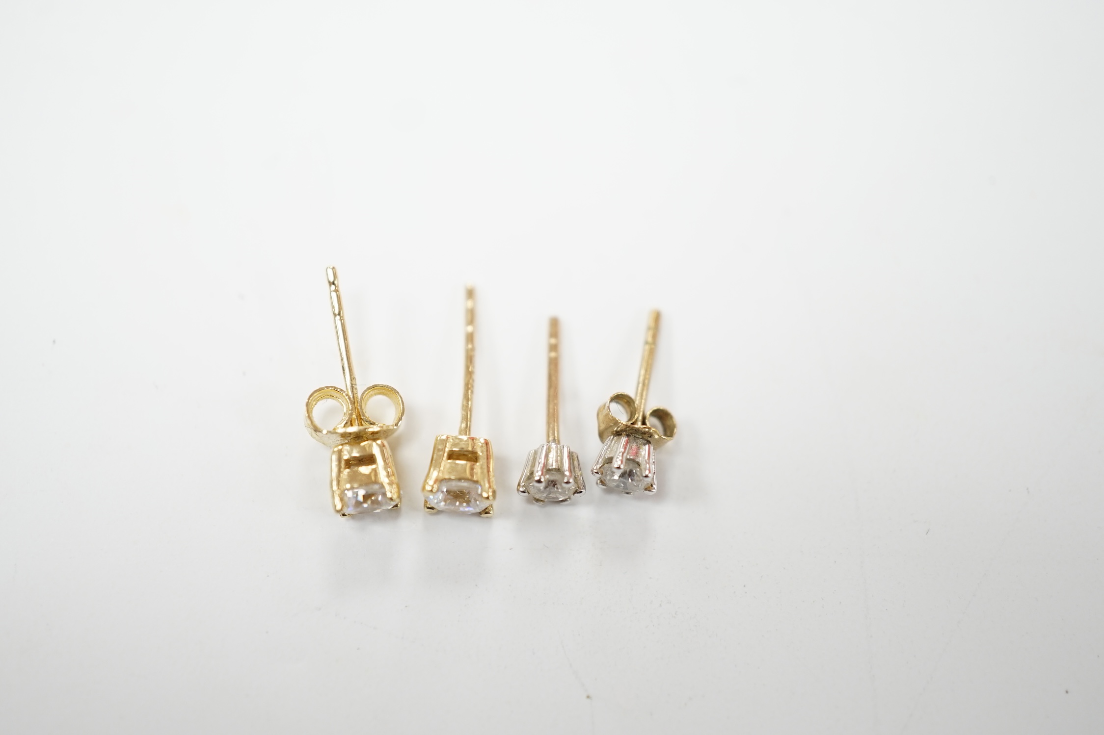 A pair of 585 and solitaire simulated diamond set ear studs and a smaller pair of 375 and solitaire diamond ear studs. Good condition.